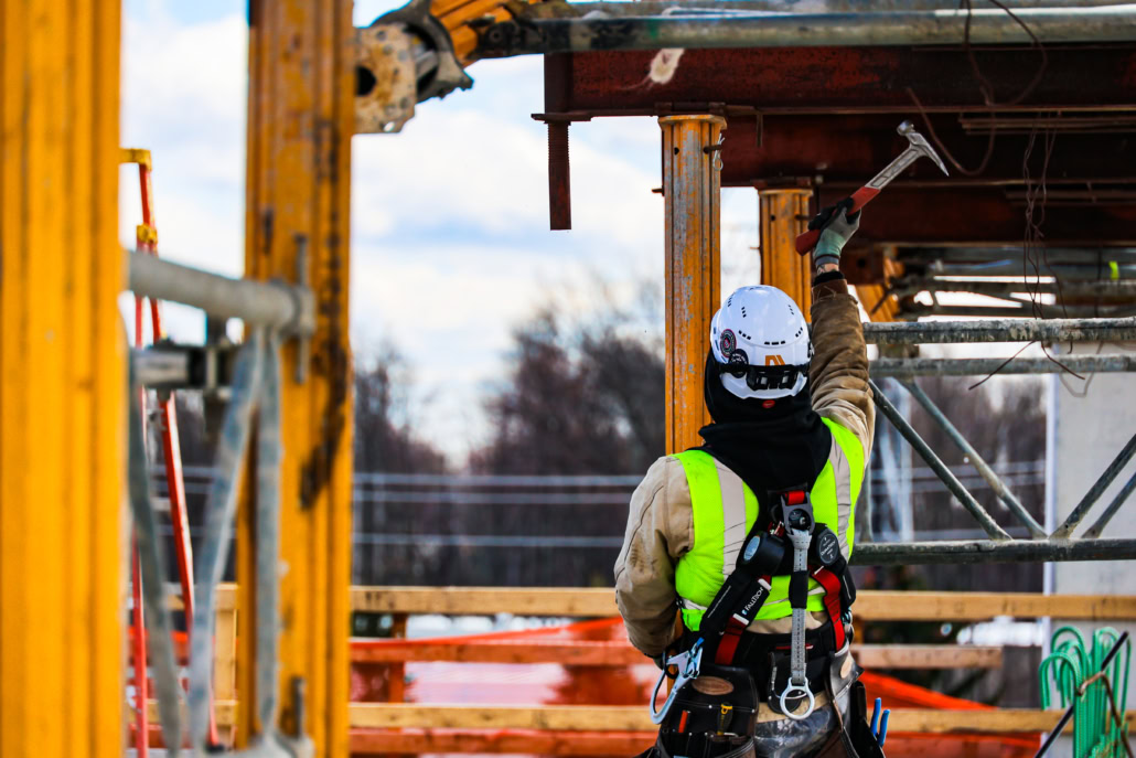 632A0040 Union Carpenter swinging hammer outside on a job site in PPE safety equipment.